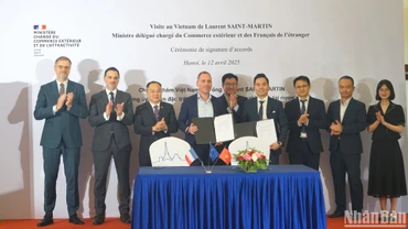 Bộ trưởng đặc trách Ngoại thương và người Pháp ở nước ngoài Laurent Saint-Martin (hàng sau, thứ 2 từ trái sang) và các đại biểu chứng kiến đại diện các doanh nghiệp hai nước ký kết thỏa thuận hợp tác. (Ảnh: TRUNG HƯNG) 