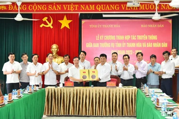 Phó Tổng Biên tập Báo Nhân Dân Quế Đình Nguyên và Phó Bí thư Thường trực Tỉnh ủy Thanh Hoá Lại Thế Nguyên trao nhau bản thỏa thuận hợp tác truyền thông giữa 2 cơ quan trước sự chứng kiến của lãnh đạo 2 đơn vị.