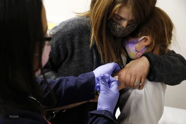 Nhân viên y tế tiêm vaccine ngừa Covid-19 cho trẻ em. (Ảnh: AFP/TTXVN)