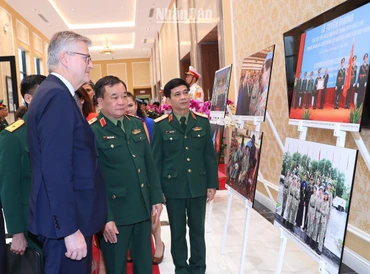 Thượng tướng Hoàng Xuân Chiến, Thứ trưởng Quốc phòng và Phó Tổng Thư ký Liên hợp quốc Jean-Pierre Lacroix cùng các đại biểu xem triển lãm ảnh về phụ nữ với hoạt động gìn giữ hòa bình Liên hợp quốc.