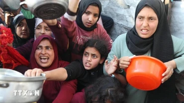 Người dân chờ nhận thức ăn cứu trợ tại Beit Lahia, miền bắc Dải Gaza ngày 22/3/2025. (Ảnh: THX/TTXVN)