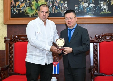 Tổng Biên tập Báo Nhân Dân Lê Quốc Minh tặng quà lưu niệm Chủ tịch hãng Thông tấn Prensa Latina Luis Enrique González Acosta. (Ảnh: DUY LINH)