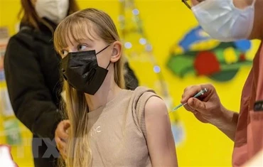 Nhân viên y tế tiêm vaccine ngừa Covid-19 cho người dân tại Berlin, Đức. (Ảnh: AFP/TTXVN)