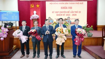 Bí thư Thành ủy Huế Lê Trường Lưu tặng hoa chúc mừng đồng chí Nguyễn Chí Tài vừa bầu bổ sung Phó Chủ tịch Ủy ban nhân dân thành phố (thứ 2 từ bên phải) và các đồng chí vừa chuyển công tác. (ảnh: Ng.Hiếu)