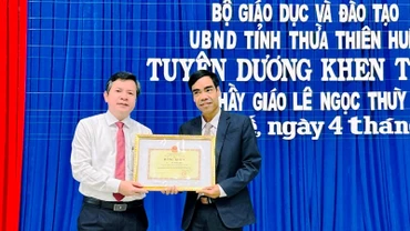 Giám đốc Sở Giáo dục và Đào tạo trao Bằng khen của Bộ Giáo dục và Đào tạo và UBND tỉnh cho thầy giáo Lê Ngọc Thùy (bên phải).