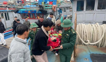 Cán bộ, chiến sĩ Đồn Biên phòng Quỳnh Phương và ngư dân vận chuyển nạn nhân lên tuyến trên điều trị.