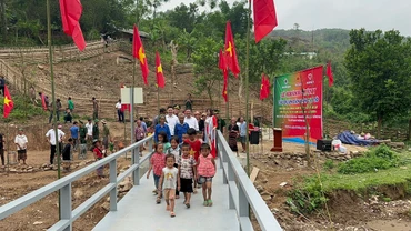 Niềm vui của dân bản và các cháu học sinh bản Nhôn Mai ngày khánh thành cầu qua suối khe Hỷ.