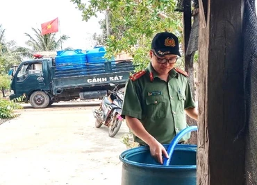 Công an huyện Ea Súp sử dụng các phương tiện chở nước sạch hỗ trợ người dân thôn 2, xã biên giới Ia Rvê sinh hoạt.
