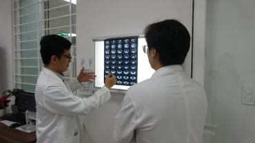 Các bác sĩ hội chẩn, phân tích tình trạng khối u của bệnh nhân trước giờ phẫu thuật. (Ảnh: ANH ĐÀO)