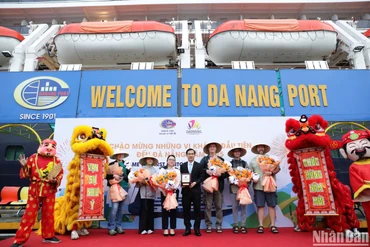 Đại diện lãnh đạo Sở Du lịch Đà Nẵng tặng hoa chúc mừng những du khách đầu tiên trên Siêu du thuyền Noordam đến Đà Nẵng (Ảnh: ANH ĐÀO)