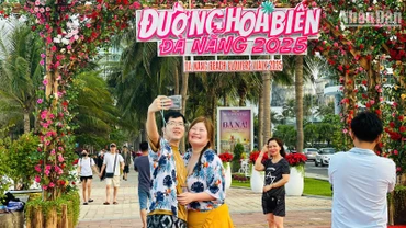 Du khách nước ngoài check-in tại Đường hoa biển Đà Nẵng chiều 30/4. (Ảnh: ANH ĐÀO)