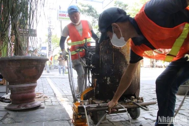 Lực lượng chức năng tiến hành phân định, kẻ vạch trên đường Khúc Hạo, phường Nại Hiên Đông, quận Sơn Trà, chiều 13/3. Ảnh: ANH ĐÀO