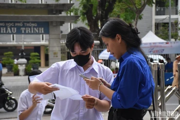 Các thí sinh được tình nguyện viên hỗ trợ, hướng dẫn đến phòng thi theo sơ đồ tại điểm thi Trường THPT Phan Châu Trinh, Đà Nẵng, chiều 26/6. (Ảnh: ANH ĐÀO)