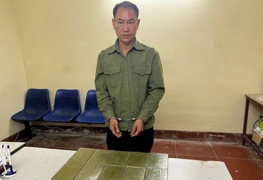 Đối tượng Mùa A Thào cùng 10 bánh heroin tại cơ quan công an.