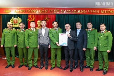 Tổng Biên tập Báo Nhân Dân Lê Quốc Minh (thứ 4 từ phải sang) và các đồng chí trong đoàn công tác trao tặng Báo Nhân Dân Xuân Quý Mão 2023 đến các cán bộ, chiến sĩ Cục Cảnh sát điều tra tội phạm về tham nhũng, kinh tế, buôn lậu. (Ảnh: THÀNH ĐẠT)