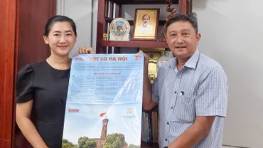 Phó Giám đốc Sở Giáo dục và Đào tạo tỉnh Vĩnh Long Nguyễn Thị Ngọc Bích phấn khởi tiếp nhận phụ san Báo Nhân dân về Cột cờ Hà Nội. 