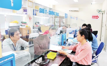 Người dân làm thủ tục hành chính tại phường Cầu Kho, Quận 1 (Ảnh THẾ ANH)