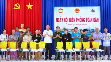 Thiếu tá Trịnh Công tự và lãnh đạo xã Đất Mới tặng quà cho hộ nghèo nhân Ngày hội Biên phòng toàn dân 2025. 