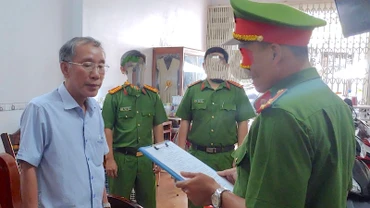 Lực lượng chức năng đọc lệnh bắt tạm giam ông Tô Quang Phúc (bìa trái), cựu Giám đốc Quỹ đầu tư phát triển tỉnh Cà Mau (ảnh Công an cung cấp). 