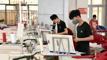 Công nhân Công ty cổ phần Nam Tiệp (Cụm công nghiệp An Xá, thành phố Nam Ðịnh, tỉnh Nam Ðịnh) may quần áo xuất khẩu. (Ảnh TRẦN HẢI) 