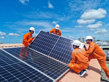 Công nhân Tổng công ty Điện lực Thành phố Hồ Chí Minh lắp đặt hệ thống điện mặt trời trên mái nhà. (Ảnh NAM DƯƠNG) 