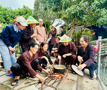 Khách du lịch trải nghiệm nấu bánh đúc khi đến với mô hình du lịch nông nghiệp tại Giang Biên (quận Long Biên, Hà Nội).