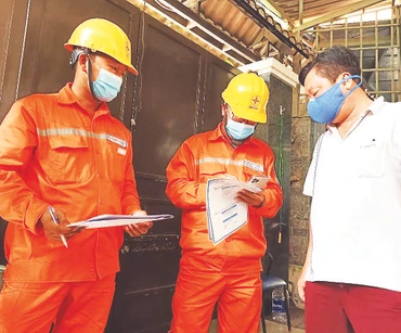 Công nhân Công ty Điện lực thành phố Thủ Đức hướng dẫn người dân sử dụng điện an toàn. 