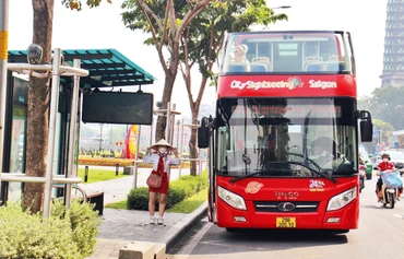 Người dân đón xe buýt tại trạm Bến Bạch Đằng, đường Tôn Đức Thắng, Quận 1. (Ảnh THẾ ANH) 