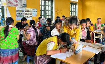 Giảng viên hướng dẫn học viên lớp đào tạo nghề tại bản Hua Huổi Luông cách ghi chép lịch tiêm phòng bệnh cho vật nuôi.