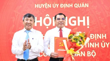 Phó Bí thư Thường trực Tỉnh ủy Hồ Thanh Sơn trao quyết định và tặng hoa chúc mừng tân Bí thư Huyện ủy Định Quán.