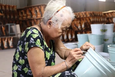 Một người thợ cao tuổi khắc hoa văn lên sản phẩm gốm Biên Hòa.