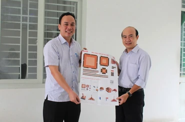 Đại diện Ban Giám hiệu Trường trung học cơ sở Nguyễn Bỉnh Khiêm tiếp nhận phụ san Báo Nhân Dân về Cột cờ Hà Nội.