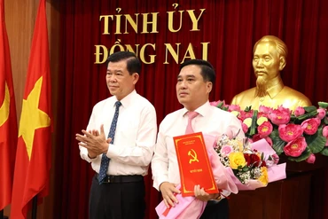 Bí thư Tỉnh ủy Đồng Nai Nguyễn Hồng Lĩnh trao quyết định và tặng hoa chúc mừng đồng chí Hồ Văn Nam.