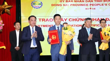 Phó Bí thư Thường trực Tỉnh ủy Hồ Thanh Sơn và Chủ tịch Ủy ban nhân dân tỉnh Đồng Nai Võ Tấn Đức trao giấy chứng nhận đăng ký đầu tư và tặng hoa chúc mừng cho doanh nghiệp.