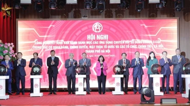 Các đại biểu bấm nút khai trương các ứng dụng chuyển đổi số dùng chung ba cấp trong các cơ quan Đảng, Chính quyền, Đoàn thể thành phố Hà Nội.
