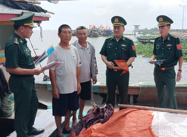 Cán bộ, chiến sĩ đồn Biên phòng Cửa Lân, xã Nam Thịnh (Tiền Hải, Thái Bình) tuyên truyền, phát tờ rơi bảo vệ an ninh biên giới biển cho ngư dân.