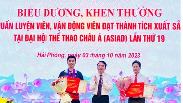 Lãnh đạo Ủy ban nhân dân thành phố Hải Phòng trao Bằng khen và tiền thưởng tặng vận động viên Phạm Quang Huy (trái) và huấn luyện viên Phạm Cao Sơn (phải).