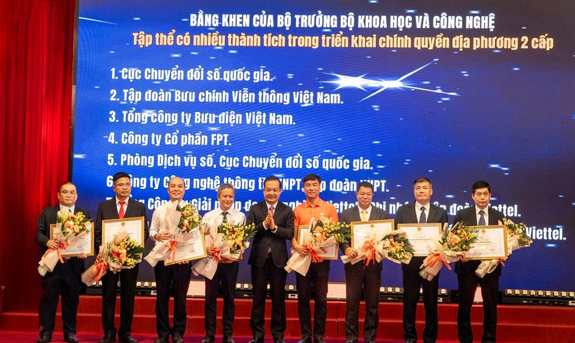 Đại diện FPT (áo cam) vinh dự nhận bằng khen của Bộ trưởng Bộ Khoa học & Công nghệ cho những đóng góp trong việc chuyển đổi các hệ thống công nghệ thông tin quan trọng đáp ứng vận hành Mô hình chính quyền 2 cấp.