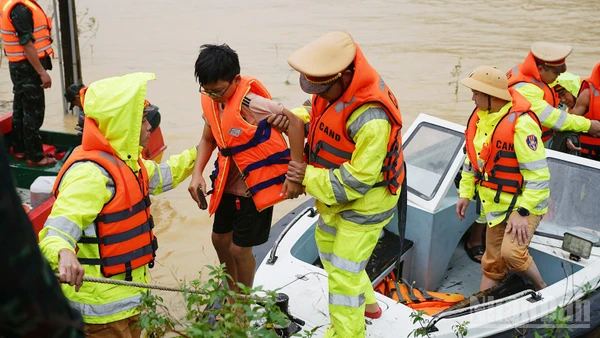 Lực lượng công an hỗ trợ người dân di chuyển khỏi vùng ngập.