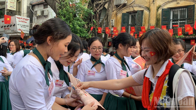 Độc giả là những người Việt Nam ở nước ngoài đón nhận tờ phụ san đặc biệt của Báo Nhân Dân từ phóng viên báo. ndo_br_z6969132443988-1a9b0c389d69e462284eddfcfd0d7011-7633.jpg