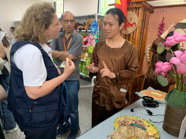 Đại biểu quốc tế hứng thú lắng nghe quy trình sản xuất cơm cháy, đặc sản Ninh Bình. a2.jpg