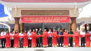 Đại biểu tham dự buổi lễ thực hiện nghi thức cắt băng khánh thành công trình. (Ảnh: HOÀNG TRUNG)