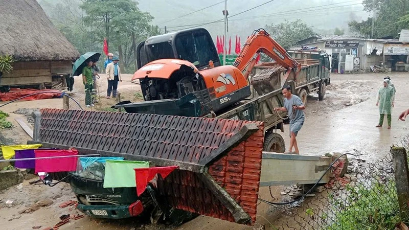 Hiện trường vụ tai nạn xe tải chở xe múc húc đổ cổng làng khiến 2 người tử vong.