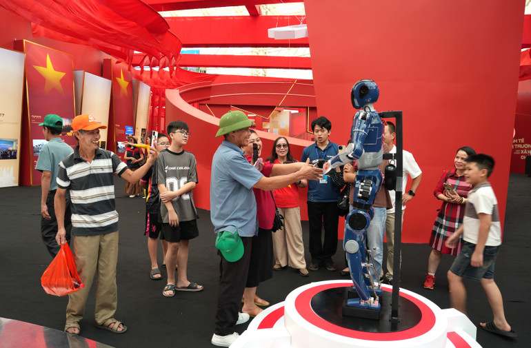 Khách tham quan tương tác với công nghệ robot. 1.jpg
