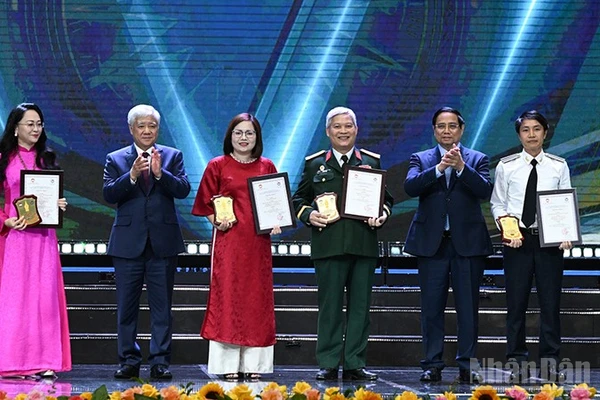 Thủ tướng Phạm Minh Chính và Chủ tịch Ủy ban Trung ương Mặt trận Tổ quốc Việt Nam Đỗ Văn Chiến (lần lượt thứ 2 và 5 từ phải sang) trao giải A tặng các tác giả, đại diện nhóm tác giả. (Ảnh: TRẦN HẢI)