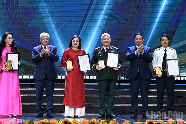 Thủ tướng Phạm Minh Chính và Chủ tịch Ủy ban Trung ương Mặt trận Tổ quốc Việt Nam Đỗ Văn Chiến (lần lượt thứ 2 và 5 từ phải sang) trao giải A tặng các tác giả, đại diện nhóm tác giả. (Ảnh: TRẦN HẢI)