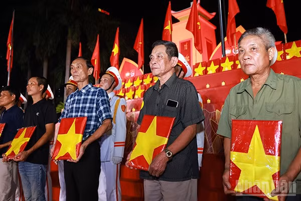 Đại diện gia đình, người thân liệt sĩ nhận di ảnh phục dựng tại buổi lễ. (Ảnh: Văn Tuyến)