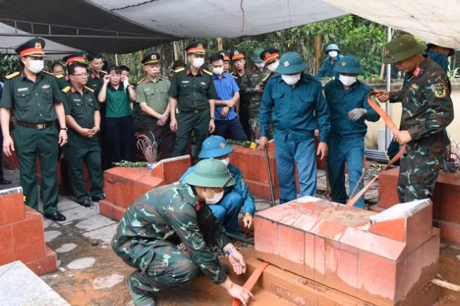 Các lực lượng tiến hành lấy mẫu tại nghĩa trang liệt sĩ Yên Trạch. (Ảnh: THIỀU CHUNG)