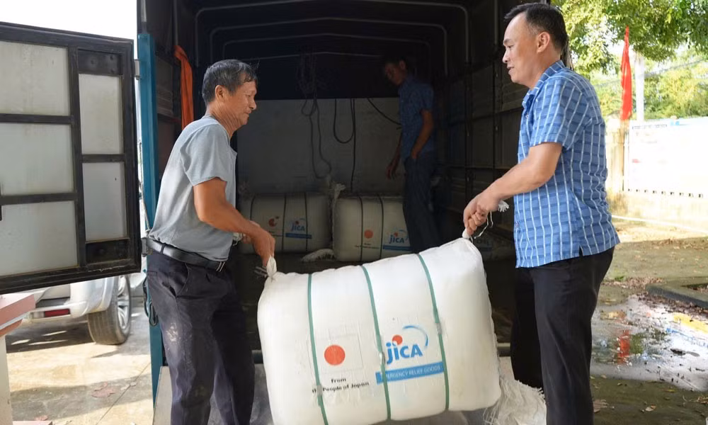 Lãnh đạo xã Hợp Thịnh hỗ trợ vận chuyển quà tặng về cho bà con các thôn. (Ảnh: MAI TOAN)