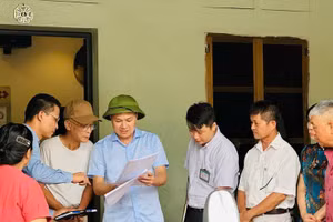 Chủ tịch Ủy ban nhân dân xã Thanh Oai (người thứ tư từ bên trái sang) đang vận động các hộ dân bàn giao mặt bằng để mở rộng Quốc lộ 21B.